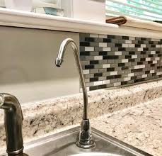 Once the tile is in position, press it firmly in place by smoothing it with your hand. Diy Peel And Stick Backsplash Review Steps The Frugal South