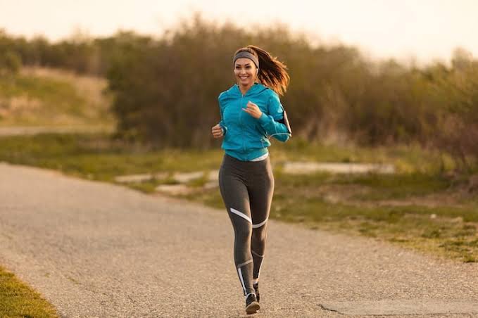Woman jogging on a scenic path at sunset
