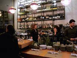 Milk crates attached to the wall beside the bar hold bottles of wine. Local Kitchen And Wine Bar Tasting Page