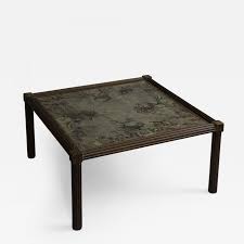 An iron base adds height and visual interest to this unusual coffee table with a storage shelf. Philip And Kelvin Laverne Rare And Unusual Coffee Table
