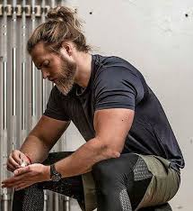A Foto Eines Muskel Bodybuilders Mit Langem Haar Und Einem Mann Brotchen Frisur Beautyblog Makeupoft Man Bun Hairstyles Long Hair Styles Hair And Beard Styles