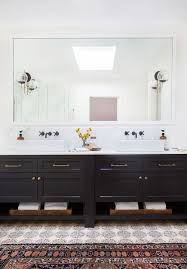 Glass droplets sconces flank a gold mirror over a black bath vanity accented with brass hardware and a brass faucet fixed above an overmount sink. Black Hardware Miss Moss Bathroom Inspiration Beautiful Bathrooms Master Bathroom