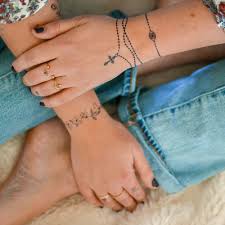 Black rosary tattoo on wrist. Give Me All The Jewelry Inspired Tattoos These 2 From The Hailey Collection Are New Faves Flashta Wrist Tattoos For Women Tattoos For Women Wrist Tattoos