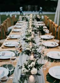A Long Table Spruced Up With An Airy Grey Table Runner Candles In Glass Candle Holders And Lush Long Table Wedding Table Runners Wedding Winter Wedding Table
