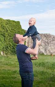 Papa et enfants jouant dans un parc