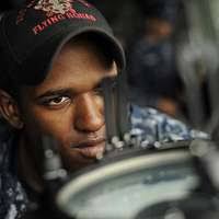 Boatswain's Mate 3rd Class Michael Expose stands master helmsman watch  during an underway replenishment aboard the amphibious transport dock ship  USS New Orleans (LPD 18).