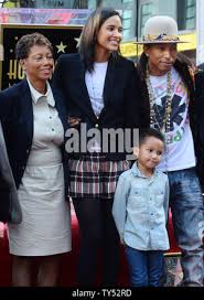 Singer and songwriter Pharrell Williams (R) poses with his mother Dr.  Carolyn Williams (L) and his wife Helen Lasichanh and their 5-year-old son  Rocket during an unveiling ceremony honoring him with the
