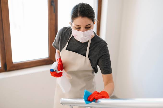 Experienced cleaning team deep cleaning a bright living room and kitchen, wiping baseboards, mopping hardwood floors, disinfecting high-touch surfaces, and polishing fixtures with professional equipment. The image highlights trusted deep cleaning services near me, deep cleaning house, deep house cleaning services near me, deep clean maid service, and home deep cleaning that leave every home spotless and refreshed.