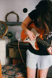 Young Brunette Woman Plays Guitar Indoors By Treasures Travels Guitar Guitar For Beginners Easy Guitar