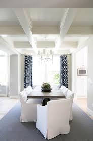 White Low Back Slipcovered Dining Chairs Surround A Dark Stained Trestle Dining Table Placed On A Low Back Dining Chairs Dining Chairs Transitional Dining Room