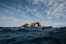 The top of darwin's arch, the famous natural stone archway in the northern galapagos islands, has crashed into the waves, according to news reports. People In Boat By Darwin S Arch Darwin Island Seymour Galapagos Ecuador South America Stock Photo Dissolve