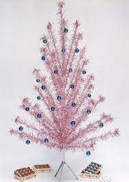 This mid century modern style tree features silver metallic pompom branches, a wooden pole with a silver finish and a white tree stand. History Lesson The Aluminum Christmas Tree Etsy Journal