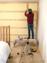 This is a twist on a board and batten, which basically means putting wood strips on your wall in a pattern. How To Diy A Board Batten Wall