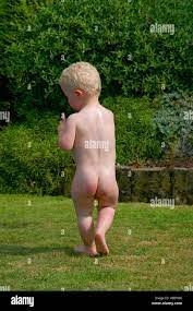 Bebé desnudo caminando en el jardín Fotografía de stock 