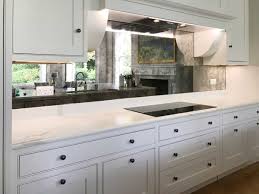 The glass cabinet fronts and the mirrored backsplash reflect light streaming in from a skylight above. Kitchen Design A Guide To Choosing The Right Finishes