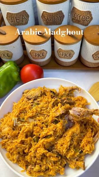 Madghout ingredients including basmati rice, lamb shanks, Gulf spices, dried black limes, cardamom pods and cinnamon sticks on a wooden table