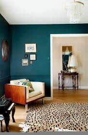An ivory carpet and couch, taupe tables and walls, and purple accessories. How To Use Bold Paint Colors In Your Living Room