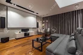 Remote controls, magazines, popcorn bowls… your living room table has a lot to take care of. Living Room With Narrow Sofa Black Glass Coffee Table And Projector Screen Stock Photo Picture And Royalty Free Image Image 89281397
