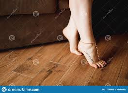 Frauen Nackte Füße Mit Eleganten Pediküre Tattoo Und Armband Auf Holzboden  in Der Nähe Leder Sofa Nahaufnahme Stockfoto - Bild von mode, hotel:  217736006