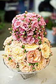 This arrangement features lovely spring florals with ivory chrysanthemum, jade pom, and yellow and pink miniature carnation blooms that sit playfully a top a cake platter. 91 Flower Cakes Ideas Flower Cake Flower Arrangements Floral Arrangements