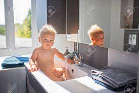 This is the cutest thing ever. Baby Taking Bath In Sink Child Playing With Foam And Soap Bubbles In Sunny Bathroom With