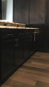 White kitchen cabinets, accented with antique brass hardware and contrasting ebony stained oak wood floors, flank a blue la cornue cornufé 90 albertine range fixed against white subway backsplash tiles and beneath a gold and blue range hood mounted between stacked white cabinets. South Hills Wet Bar Germansen Woodwork And Design