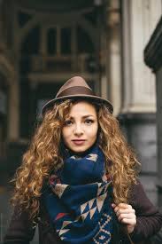 Hair that is coiled to create a curly effect. Portrait Of Beautiful Woman With Hat And Curly Hair In Urban Environment By Aleksandar Novoselski
