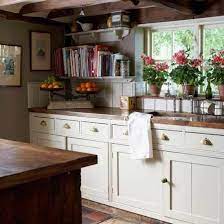 Reclaimed wood beams accentuate the vaulted ceiling and pop against the snowy cabinets and subway tile below. Designarthouse Com English Country Kitchens Cottage Style Kitchen Cottage Kitchens