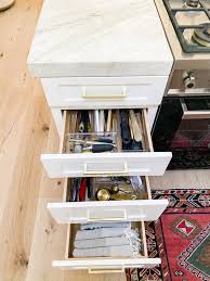 This storage hack is a bit more involved to implement, but if your kitchen cabinets are just too full, adding hidden drawers to your toe kick areas maximizes cabinet space and is the perfect solution for storing flat or rarely used items. How To Organize Kitchen Drawers Modern Glam Interiors