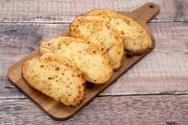 Use a spoon to evenly distribute the wash. How To Make Restaurant Style Cheesy Garlic Bread At Home