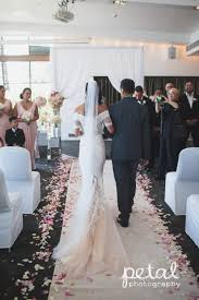 White carpet, chairs decorated with red ribbons. Indoor Wedding Ceremony At Dockside L Aqua Terrace Room Ceremony Decorations Included Wedding Aisle Decorations Wedding Ceremony Decorations Wedding Aisle