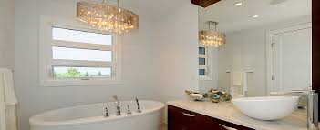 Chic bathroom features a darlana lantern in antique brass hanging over a freestanding tub placed atop a gray porcelain tiled floor flanked by a glass walk in shower to the left and a water closet finished with a gray door to the. Add A Touch Of Glamor To Your Master Bath With A Bathroom Chandelier