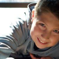 A young boy in a white shirt and blue tie. Child happiness joy.