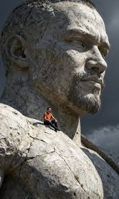 Prompt: Transform the person from the attached photo into a scene where he  is sitting