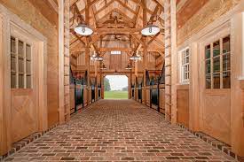 Panoramic shot of a mountainside with the old wooden barns and horse on the meadow. Carolina Horse Barn Handcrafted Timber Stable