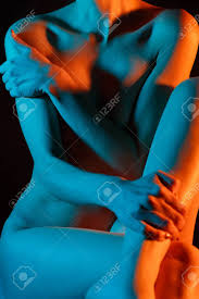 Beautiful Naked Girl In A Blue-orange Light Without A Face, Left Hand On  Her Right Shoulder, Right Hand On Her Left Foot. Stock Photo, Picture and  Royalty Free Image. Image 135794800.
