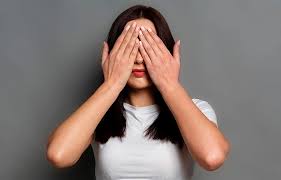 mujer con miedo, tapándose los ojos