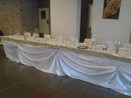 nappe blanche en tissu ruban de bordure or jupon drape blanc photophores en accessoires table settings table