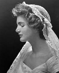 For her wedding, Jackie Kennedy wore an Ann Lowe dress that featured an 50  yards of silk taffeta, a portrait neckline, bouffant skirt, pleated bodice,  scalloped hem and large rosettes and small