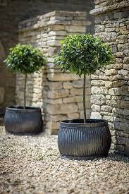The espresso brown color lends it a contemporary feel. Summer Style Modern Farmhouse Style Love The Metal Planter Pots With The Topiaries Gorgeous Large Garden Pots Large Outdoor Planters Large Planters Pots