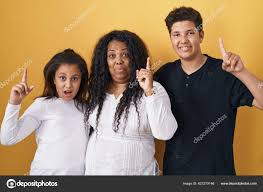 Family Mother Daughter Son Standing Yellow Background Pointing Finger  Successful Stock Photo by ©Krakenimages.com 627279146