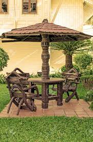 The metal garden range also includes wrought iron furniture that looks amazing with beautifully crafted designs. Garden Furniture Chairs And Table Under Wooden Umbrella At Garden Stock Photo Picture And Royalty Free Image Image 23996234