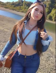 A close up of a woman in a blue top and jeans - SeaArt AI