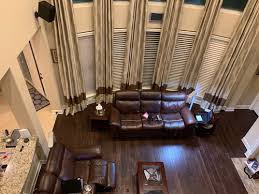 In this living room, the furniture is paired with decorative wallpaper in an abstract blue pattern. Coffee Table Color With Dark Brown Sofa And Dark Brown Floors