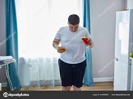 Fat teen boy check his weight on scales Stock Photo by ©ufabizphoto  407892926