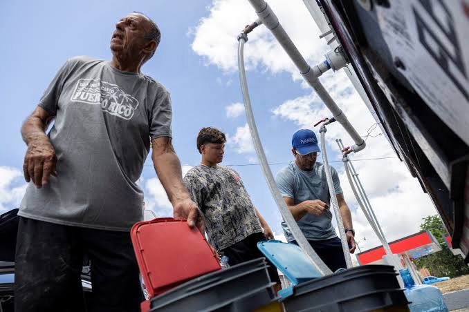 A water distribution site in Puerto Rico as residents wait to fill containers during an ongoing drought.