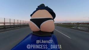 オートバイに乗って公道でお尻を点滅させるミニスカートのセクシーなティーン