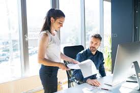 Two Business People In The Office Working Together By Halfpoint Two Business People In The Workplace W Business People Business Photos Photoshop Photography