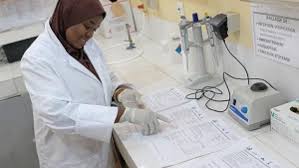 Technicien en blouse blanche travaillant sur un équipement de laboratoire ou médical au Niger