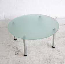It features a round, glass top and a steel base with a this sleek coffee table that is neither round nor square. Round Glass Table On Four Chrome Legs Glass Coffee Table Small Glass Table